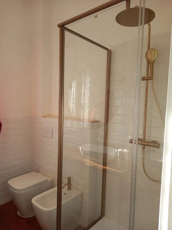 Bagno con doccia walk-in, finiture in ottone satinato e rivestimento in piastrelle subway, ristrutturato da Fattarelli S.r.l.